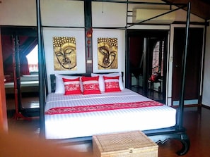 A bed with a red and white bedspread, two red pillows, and a headboard with two golden wall art pieces. - Coconut River beach Holiday Villa (Koh Samui)