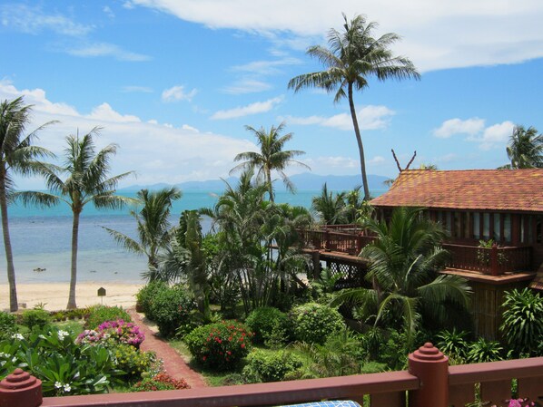 A tropical resort with a beach view, palm trees, and a wooden building with a red roof. - Coconut River beach Holiday Villa (Koh Samui)