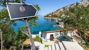 En kustutsikt med en skylt som visar vägen till ”The Beach House and Wellness”.