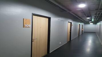 Pasillo con puertas numeradas 108, 109 y 110, que dan a habitaciones individuales.