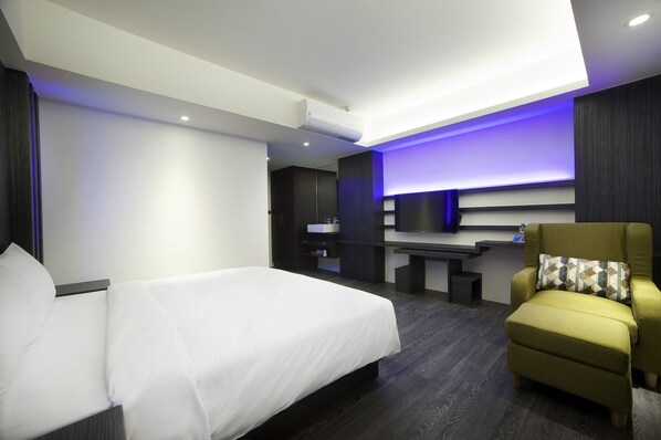 A modern hotel room with a bed, a desk, and a TV. - Seven Fukun Hotel (Jiaoxi)