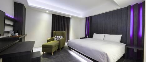 Una habitación de hotel moderna con una cama grande, un escritorio y una silla.