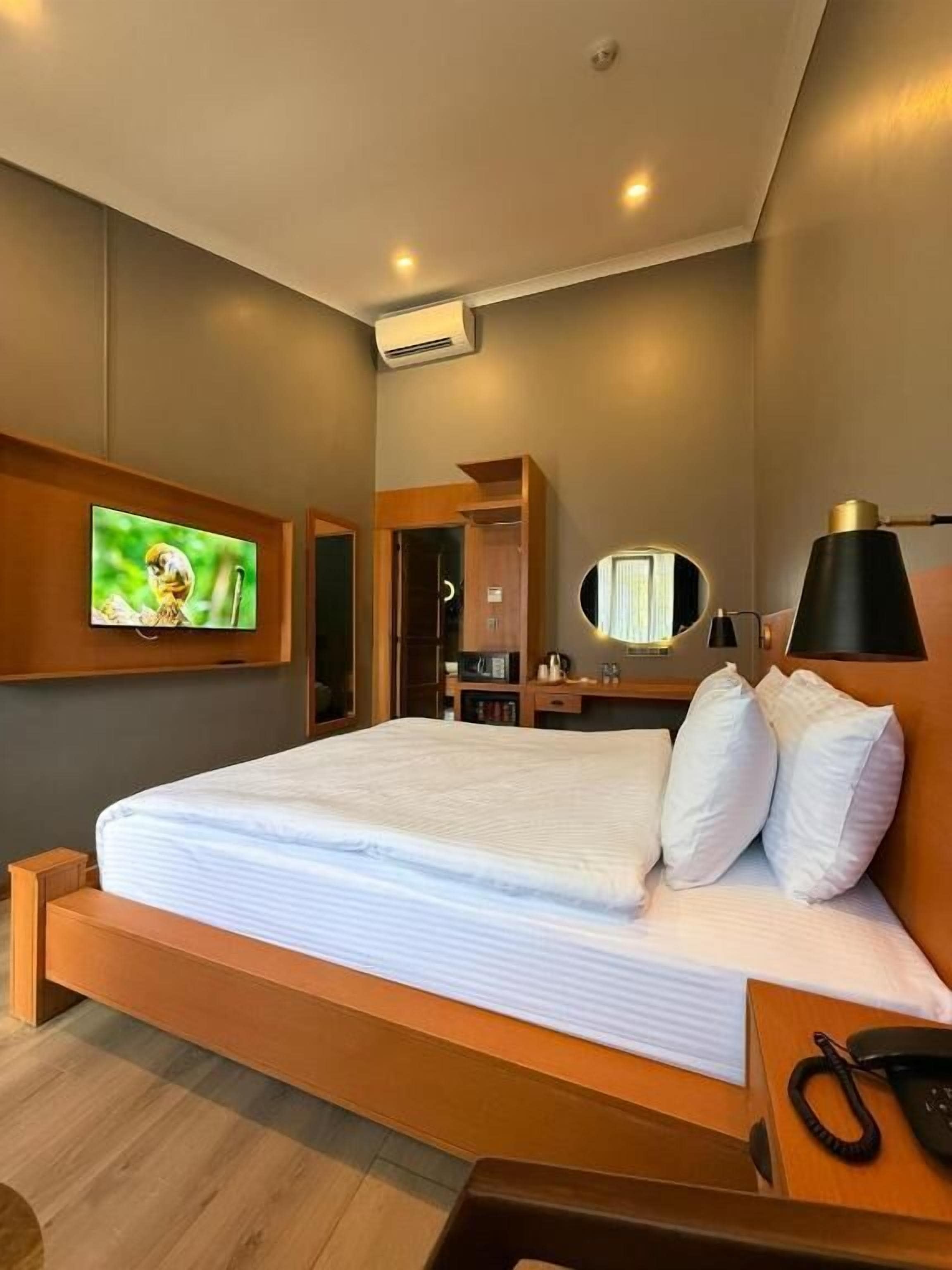 Deluxe kamer | Luxe beddengoed, een minibar, een kluis op de kamer, een bureau