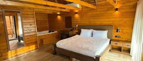 A wooden cabin bedroom with a bed, bedside tables, and a wooden floor.