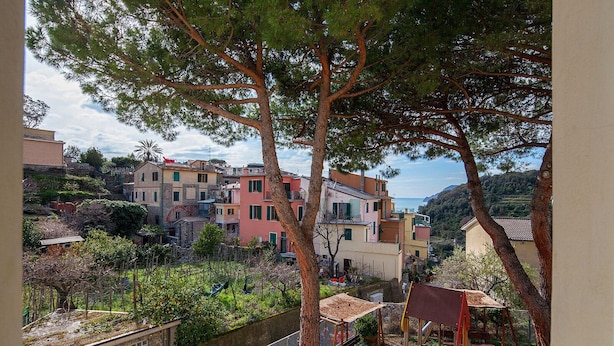 A coastal town with colorful buildings, a playground, and a view of the sea. - Ostello Corniglia (Vernazza)