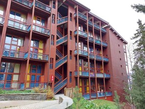 Um edifício com vários andares, varandas e escadas.