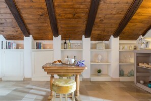 A rustic kitchen with a wooden table, a chair, and various kitchen items. - Le Cupole - Suite Panoramica by Wonderful Italy (Ostuni)