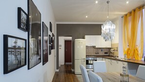 A modern kitchen with a refrigerator, stove, and dining area.