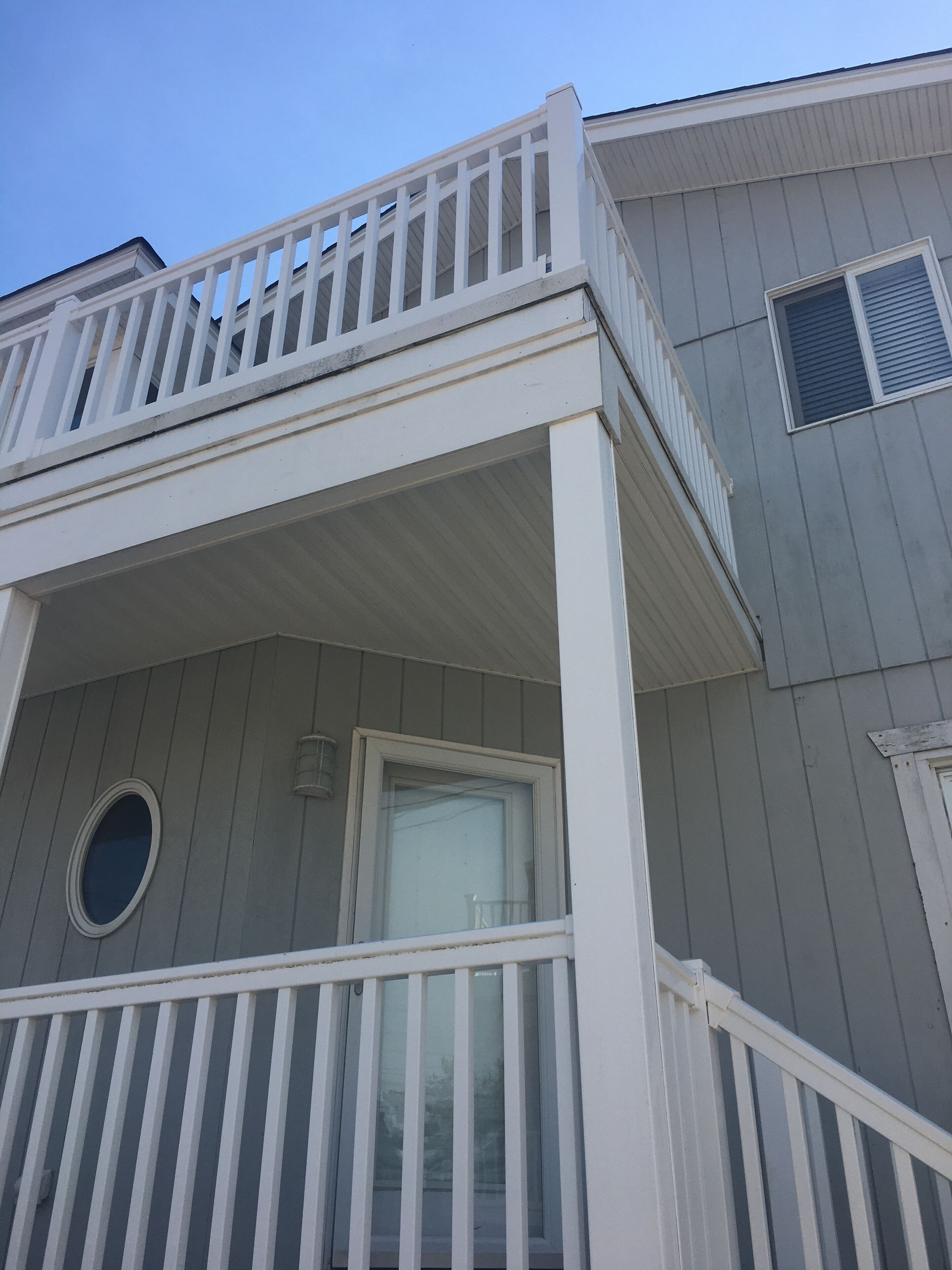 A two-story building with a balcony and a window.