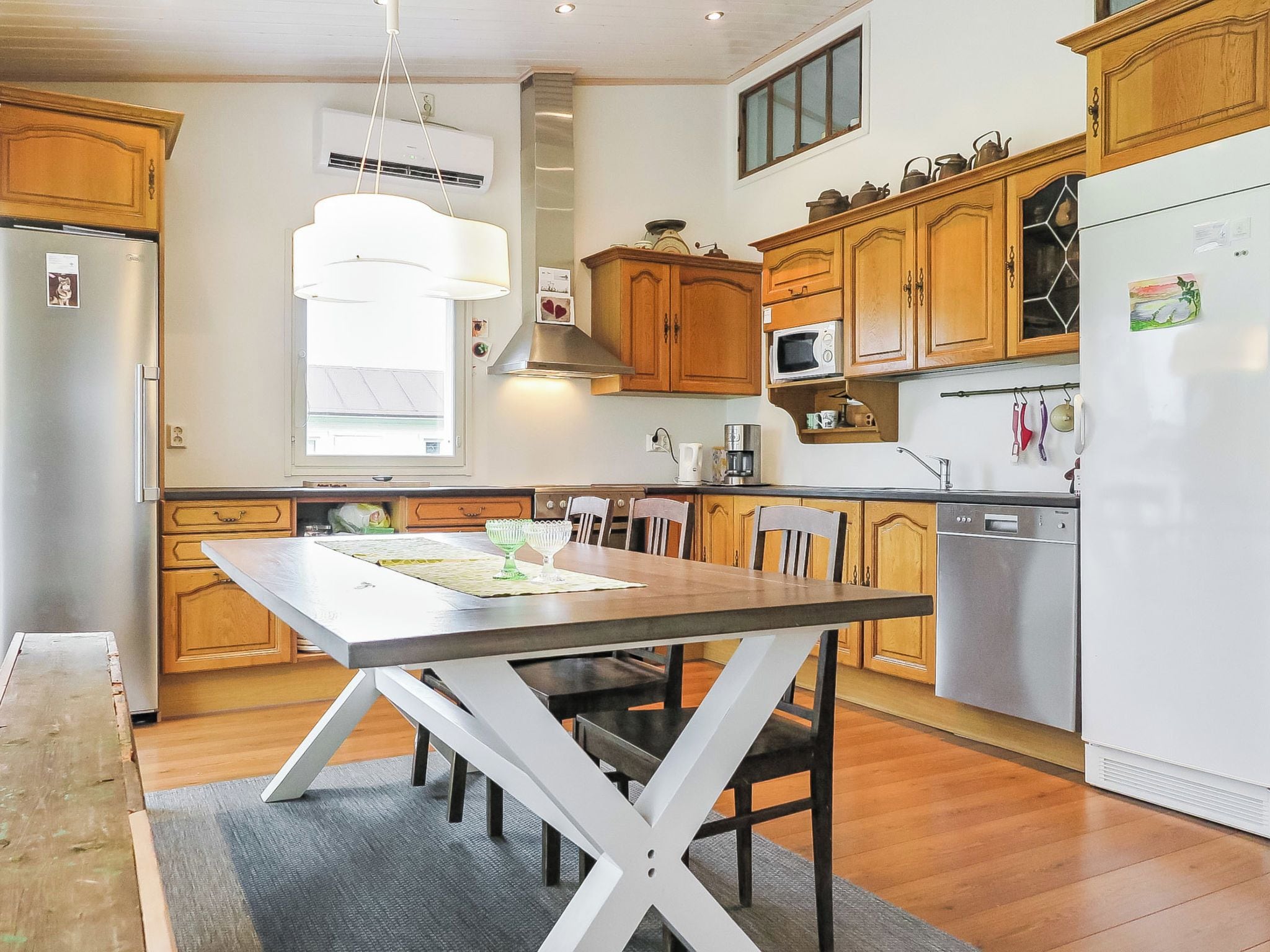 Une cuisine moderne avec des meubles en bois, un îlot central et des appareils électroménagers en acier inoxydable.