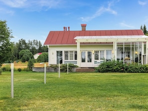 A two-story house with a red roof, a covered porch, and a well-maintained lawn. - Kotiranta by Interhome (Muhos)
