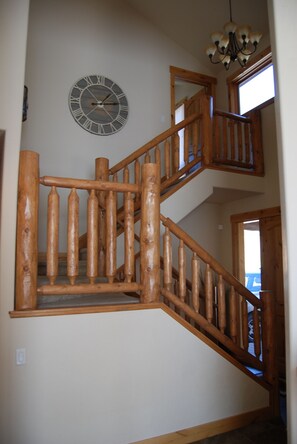 A wooden staircase with a clock on the wall.