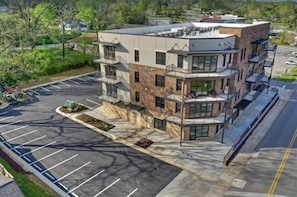 Stylish building with balconies and green surroundings.