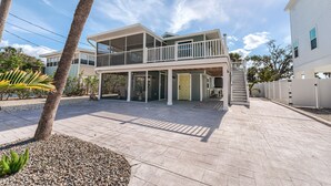 Een tweelaags huis met een balkon, een overdekt terras en uitzicht op de omgeving.