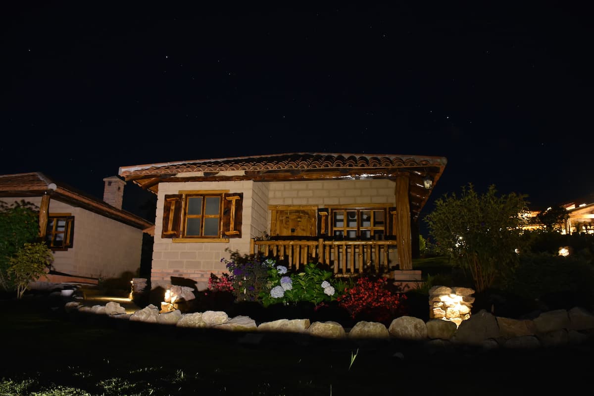 A house with a tiled roof, a stone facade, and a wooden porch.