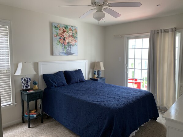 A bedroom with a large bed, two bedside tables with lamps, a ceiling fan, and a window with curtains. - 5 Star, Beach-block, Garage, Bikes, Porch, Great Location, Open Layout. (Ocean City)