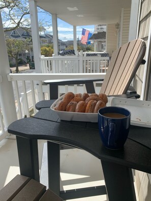 A table with a plate of donuts and a blue mug on a porch. - 5 Star, Beach-block, Garage, Bikes, Porch, Great Location, Open Layout. (Ocean City)