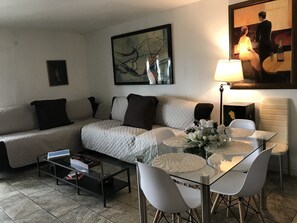 Relax in this stylish living room with a sofa, coffee table, and dining area.