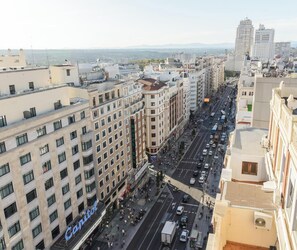 A hotel with multiple floors, a central courtyard, and a view of the cityscape.