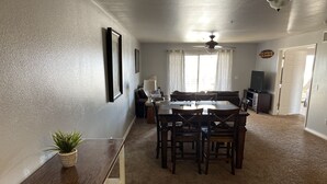 A dining area with a wooden table and chairs, a potted plant, and a ceiling fan. - Kings View Condo, Boaters paradise, Unit 408 (Lake Havasu City)
