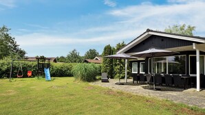 Un espace patio avec des sièges extérieurs et une partie abritée.