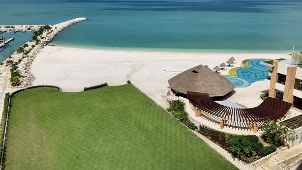 Un complexe hôtelier doté d’une plage, d’une piscine et d’une vaste pelouse.