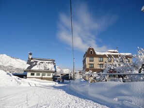 A hotel with a snow-covered roof and a clear blue sky. - New Fukudaya (Minamiuonuma)