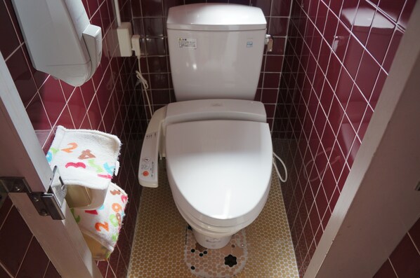 A small bathroom with a toilet, a hand dryer, and a towel rack. - New Fukudaya (Minamiuonuma)