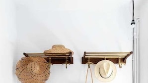 A rustic interior with a wooden bench, a wall-mounted hat rack, and a hanging bag. - Stylish home with patio 5 mins to beach (Sitges)