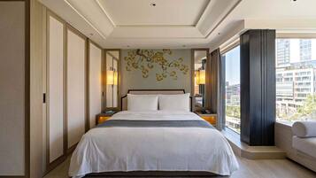 Habitación de hotel moderna con una cama grande, vistas a la ciudad y un adorno en la pared.