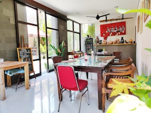 Enjoy meals in this dining area with a long table, chalkboard menu, and comfortable seating.