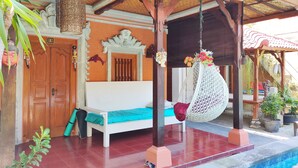 A room with a bed, a hanging chair, a wooden door, and a window. - G Saskara Homestay (Denpasar)