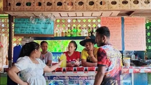 A food stall with a menu board and a sign offering a free transport service.