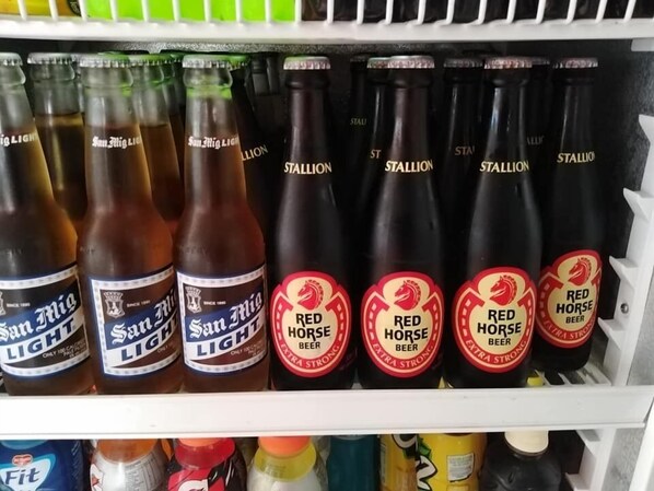 Jääkaapilla varustettu esittelyteline, jossa on useita erilaisia olutpulloja, mukaan lukien esimerkiksi San Miguel Light- ja Red Horse -oluet.