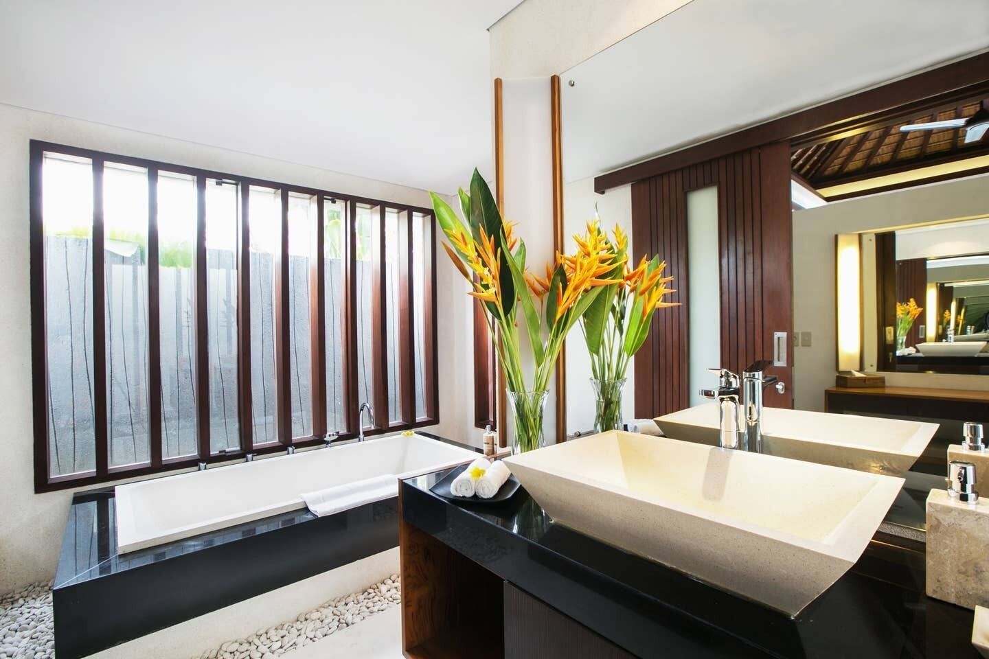 A modern bathroom with a large window, two sinks, and a mirror.