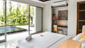 Un dormitorio moderno con una cama grande, un escritorio y vistas a una piscina.