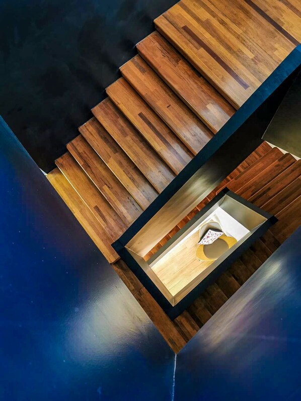 A modern staircase with wooden steps and a glass enclosure at the bottom.