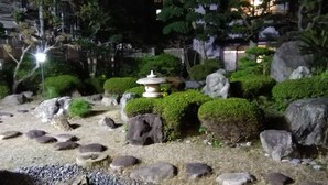 A well-maintained garden with a stone lantern, rocks, and neatly trimmed bushes. - Mitsui Bekkan (Yonago)