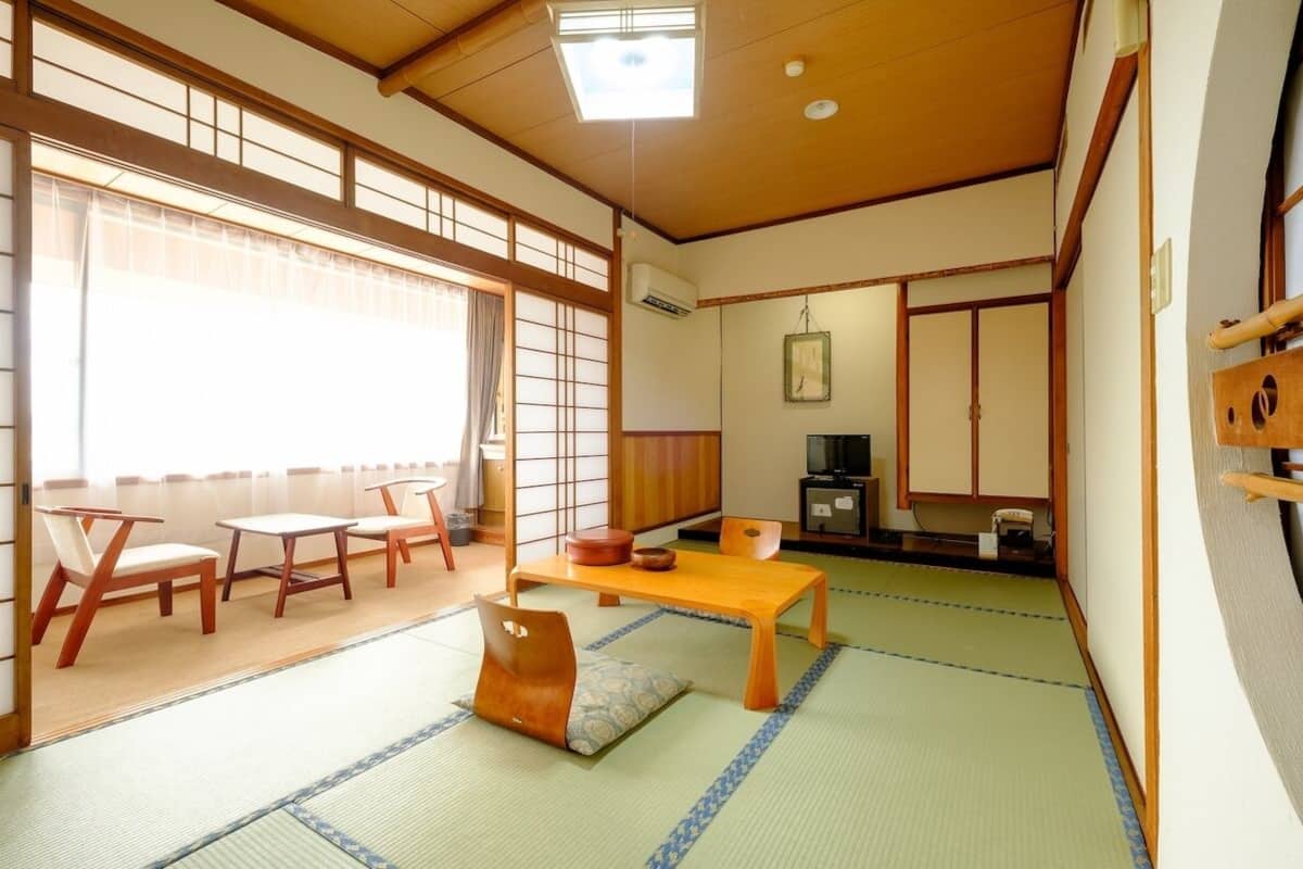 Een traditionele Japanse kamer met tatami vloerbedekking, een lage houten tafel en een schuifdeur.