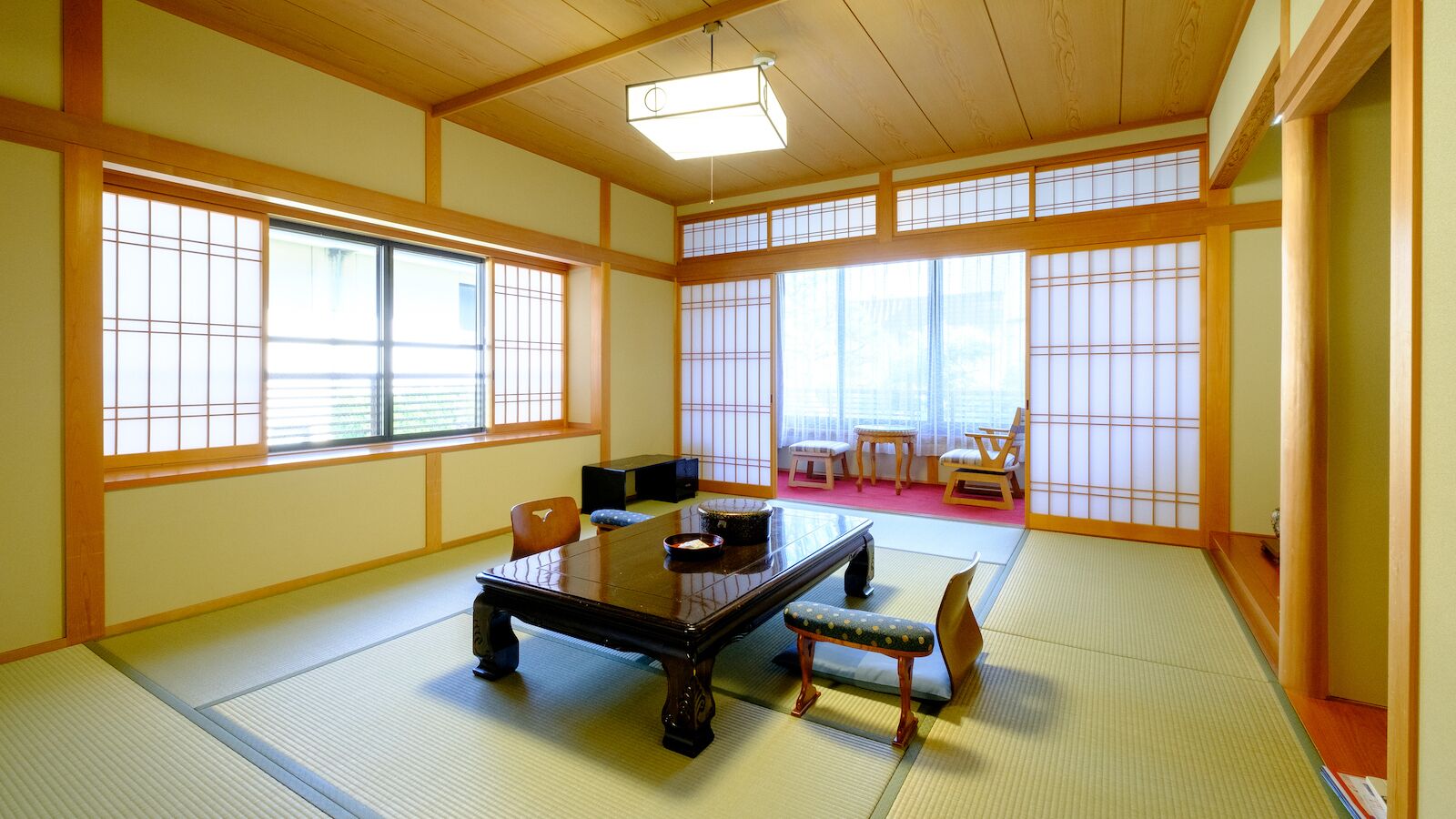 A traditional Japanese room with tatami flooring, a low table, and sliding doors.
