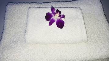 A white towel with a purple flower on it.