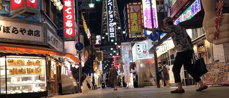 A street scene with illuminated signs and a traditional lantern.