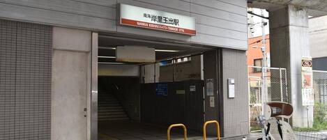 A parking garage entrance with a sign reading "Nankai Koshinoto Tamade Stn."