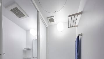 Un baño pequeño con inodoro, lavamanos y ducha.