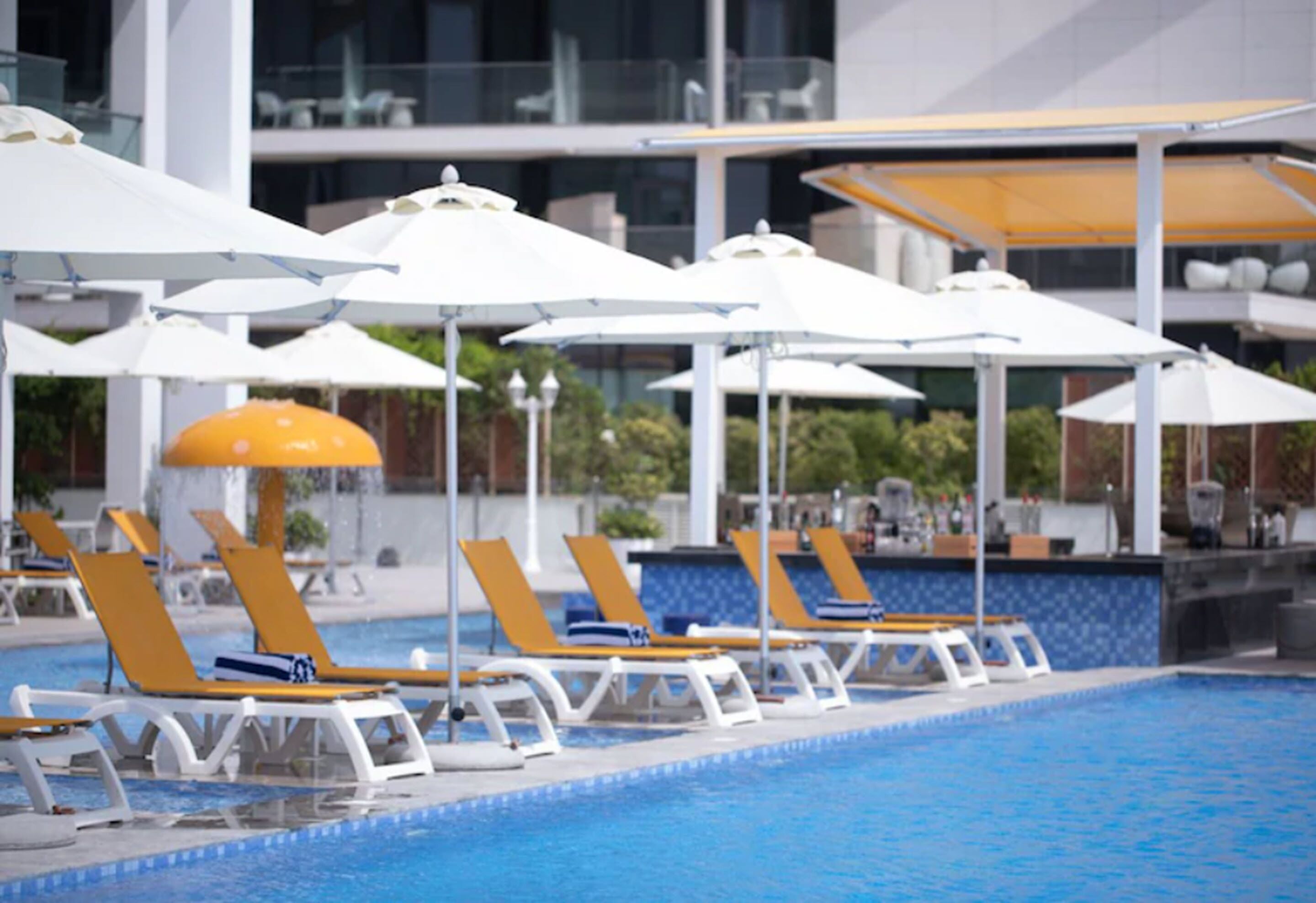 Ein Poolbereich mit Liegestühlen und Sonnenschirmen.