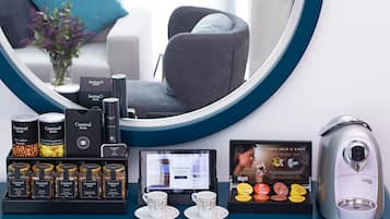 A coffee station with a coffee machine, a selection of coffee pods, and a tablet displaying a menu.