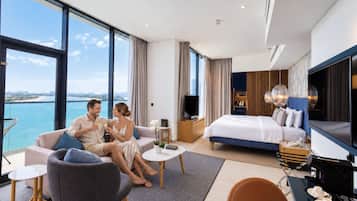 Une chambre d’hôtel dotée d’une grande fenêtre, d’un lit, d’une télévision et d’un coin salon.