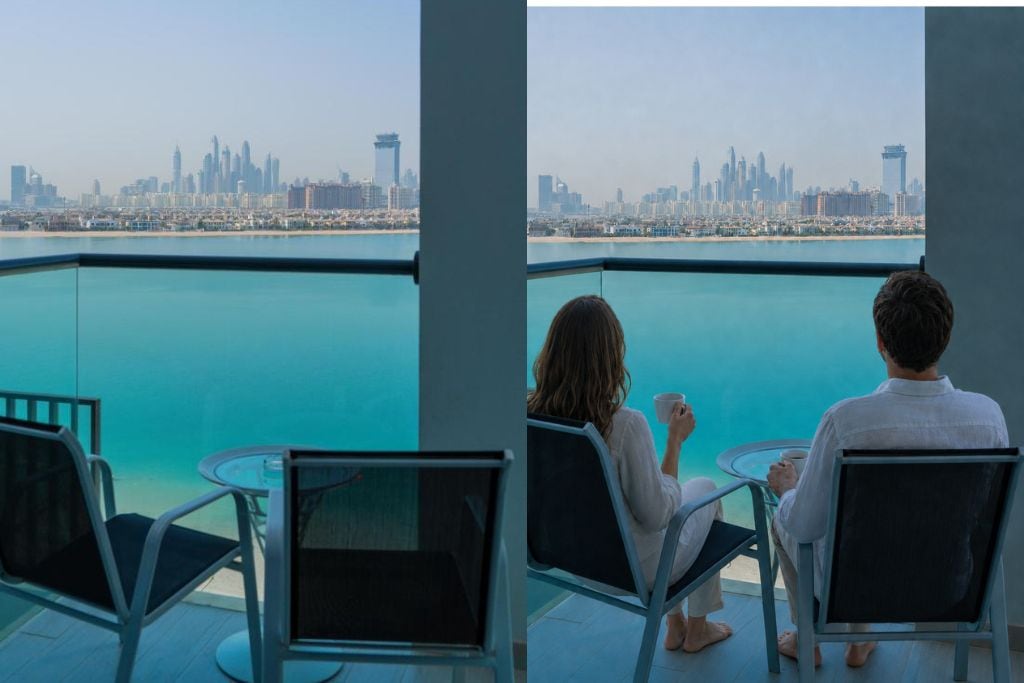 A balcony with a city view, two chairs, and a table.