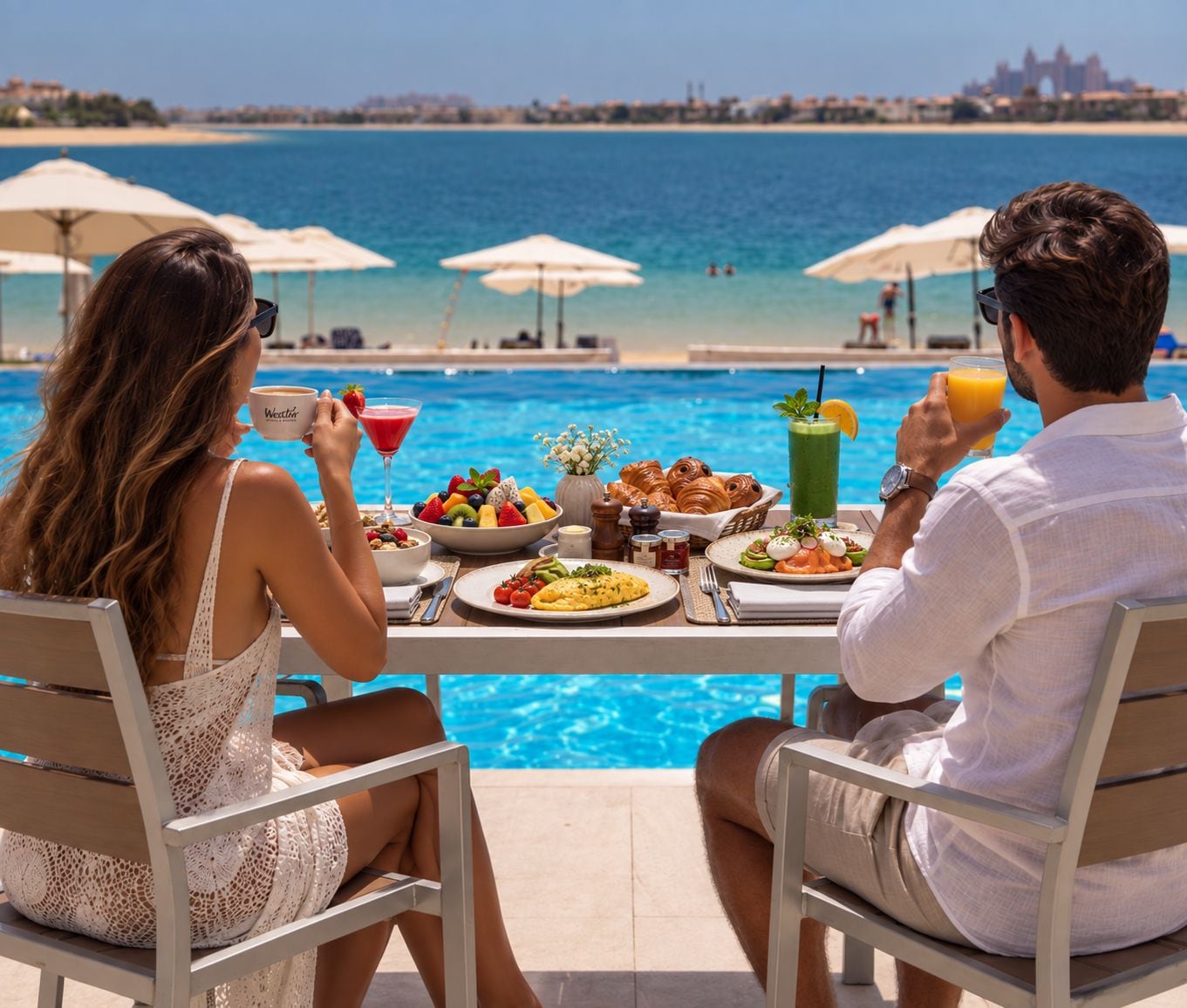 Una pareja cenando junto a una piscina con vistas al mar y al horizonte urbano.