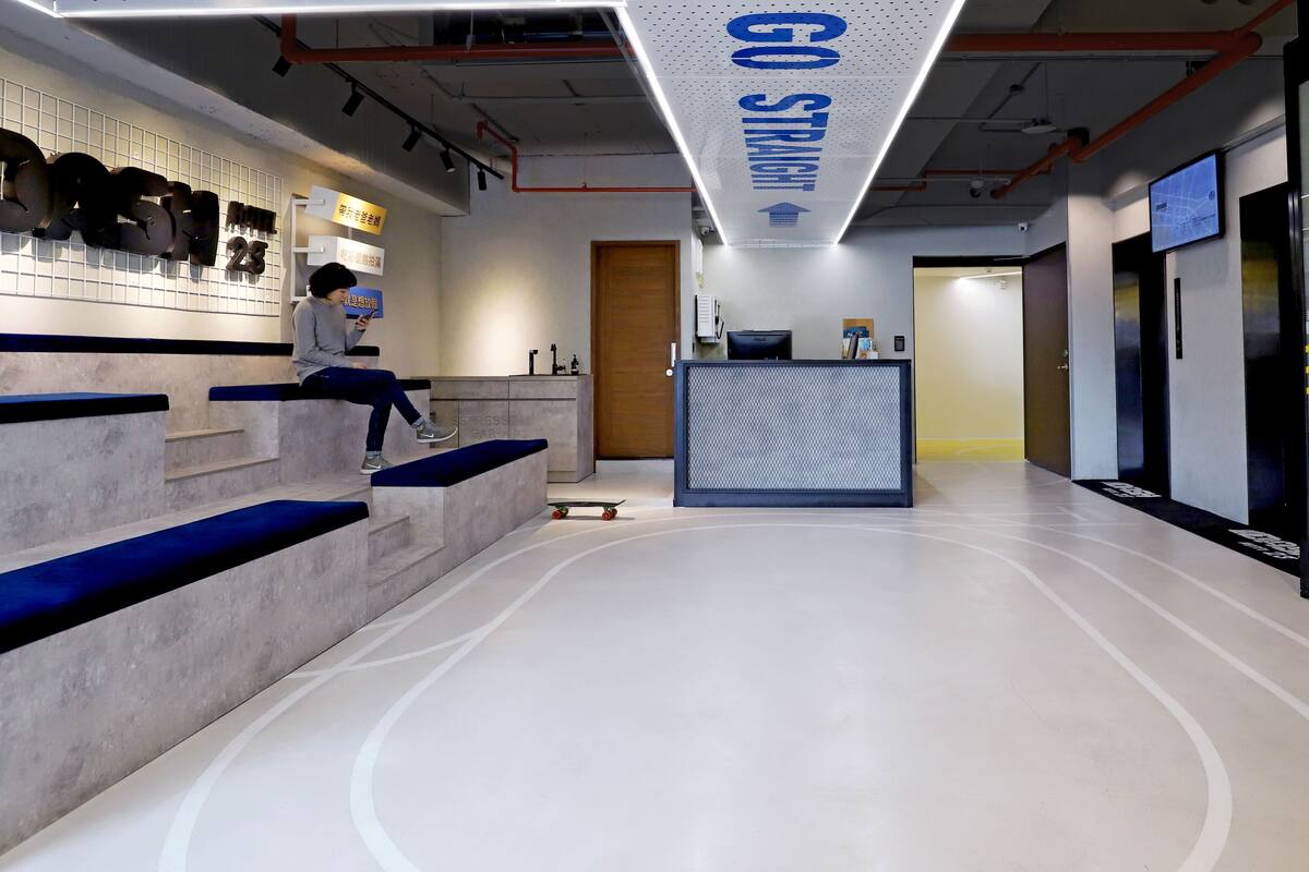 A modern reception area with a concrete reception desk, blue steps, and a 'GO STRAIGHT' sign.